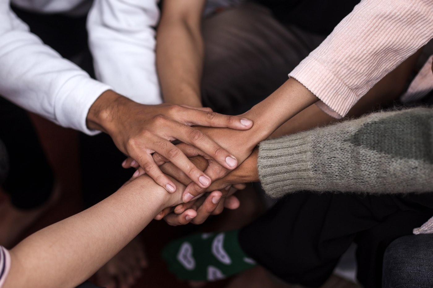 A group of people stacking their hands together