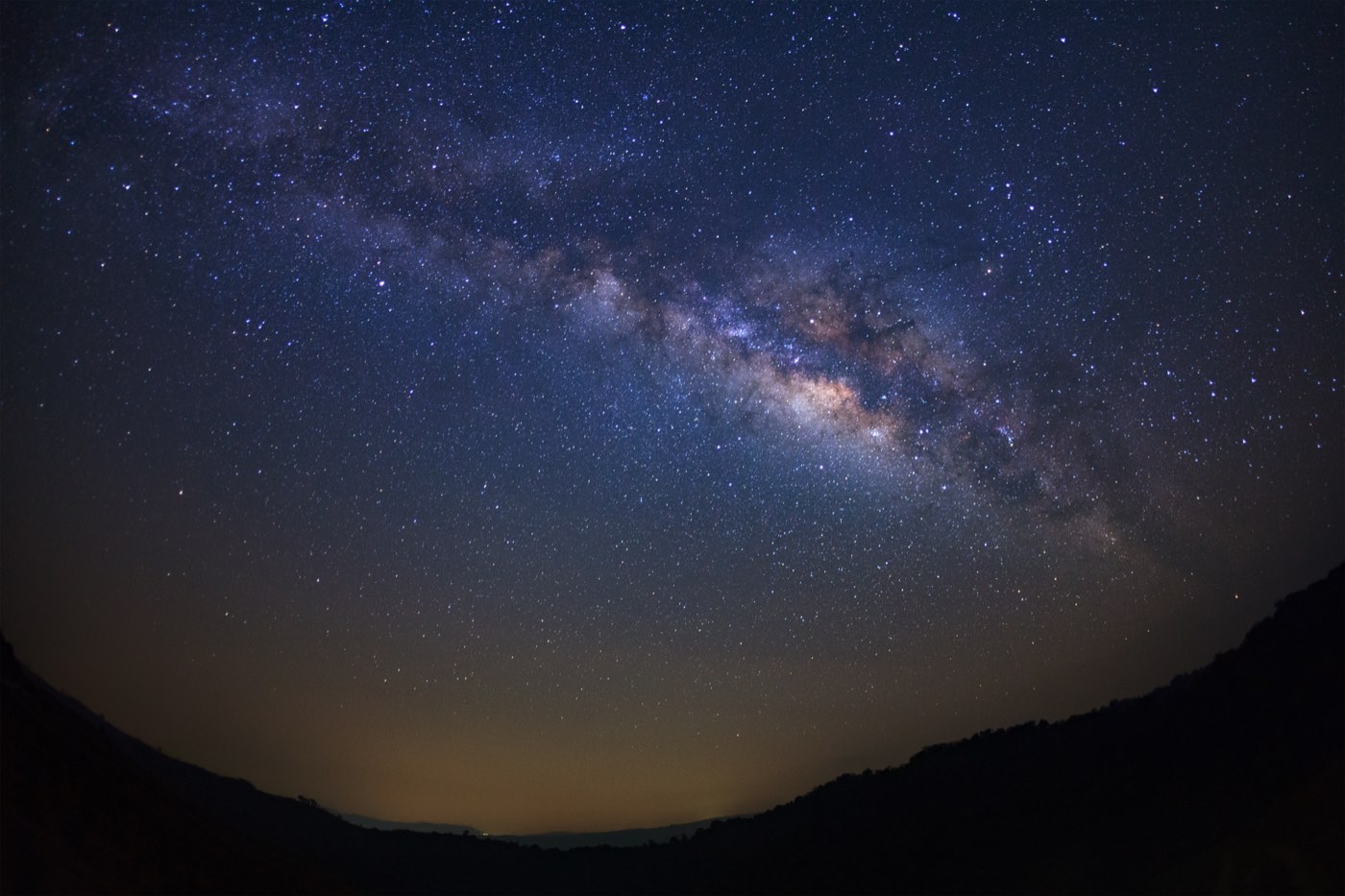 The Milky Way across a star-filled sky above dark mountains