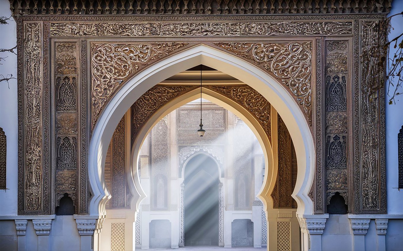 Sunlight streaming through an ornate arched passage
