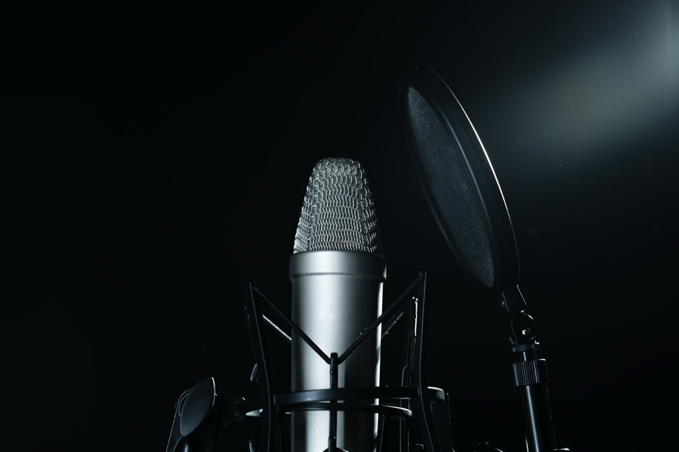 Studio microphone and pop filter against a dark background